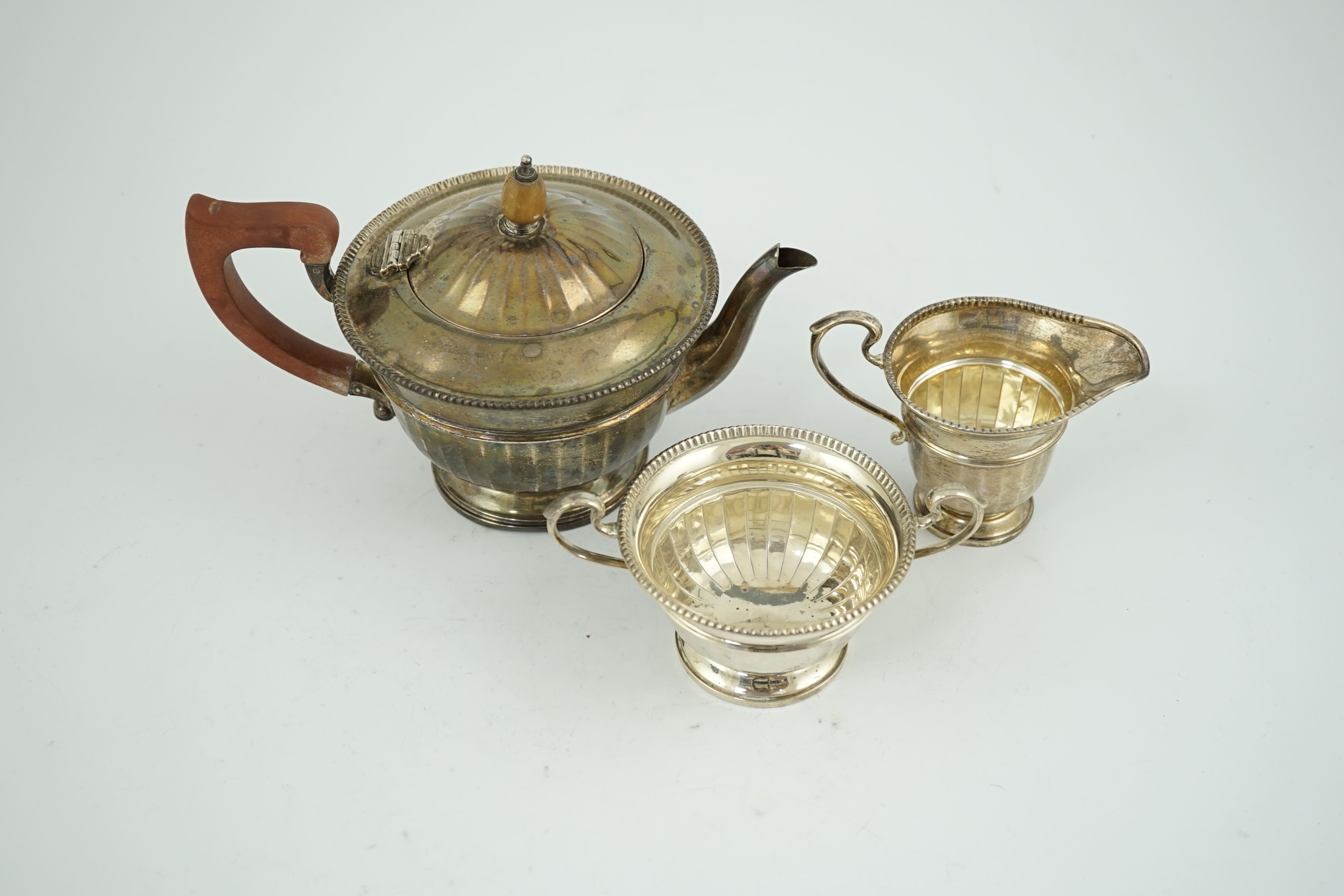 A George V panelled silver three piece tea set, by Adie Brothers